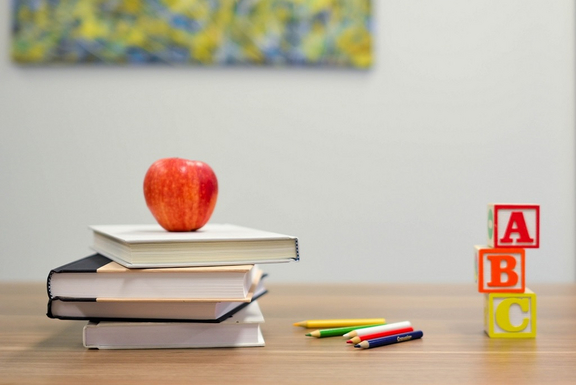 Schreibtisch mit Büchern und einem Apfel